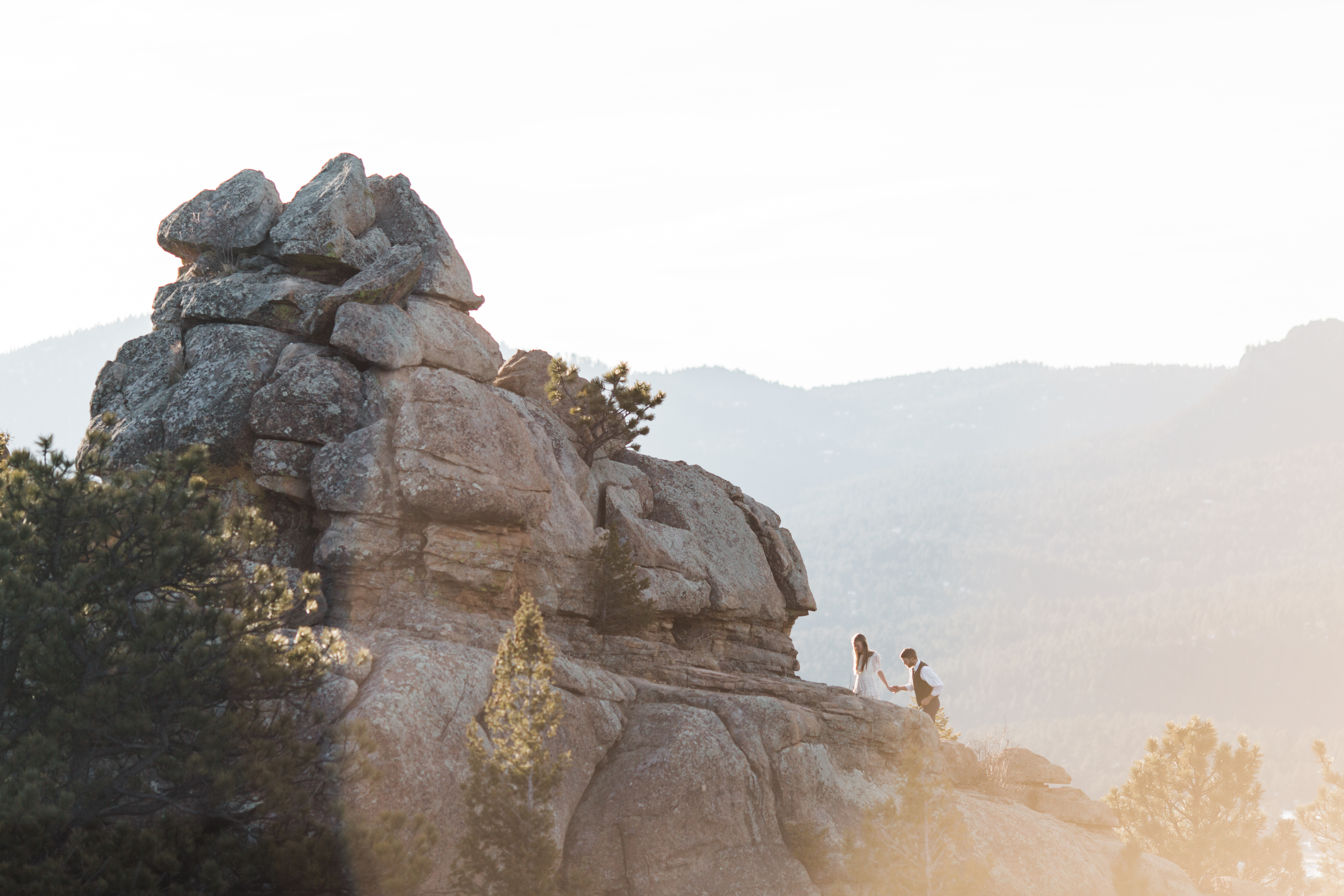 Anne and Caleb scrambled up a rock outcropping at the foothills of Colorado's Rockies at sunrise for their adventure elopement.